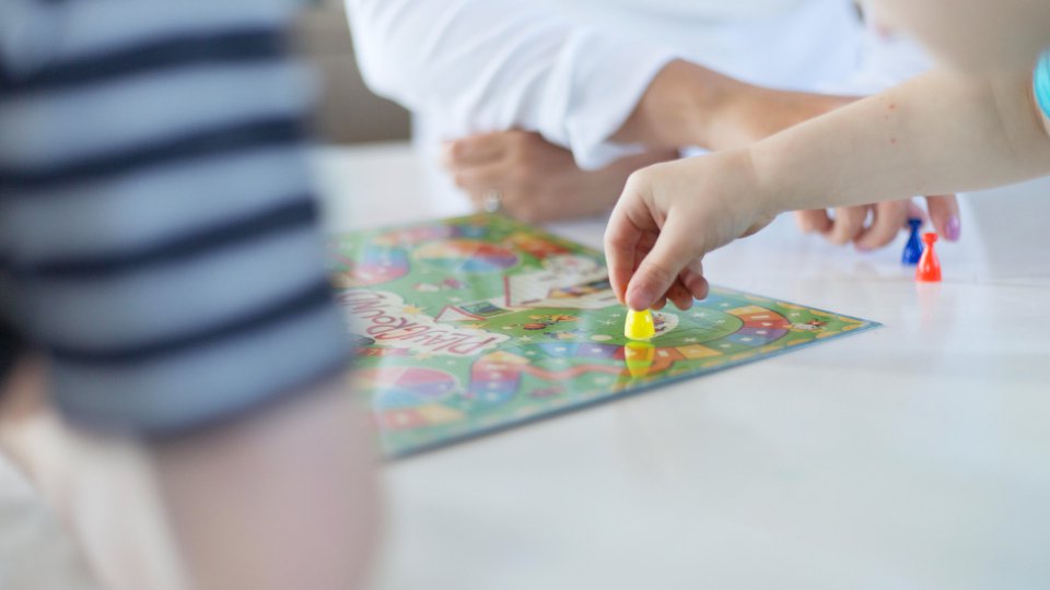 Enfants qui jouent à un jeu de société sur une table, vus de près