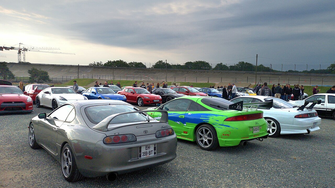 Toyota Supra, Mitsubishi Eclipse and other Japanese sports cars parked at an enthusiast meet