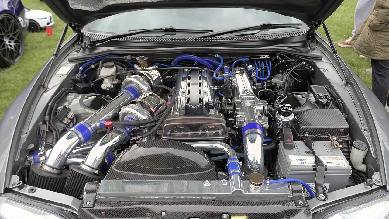 Modified Toyota Supra engine bay with a 2JZ inline-six at a car show