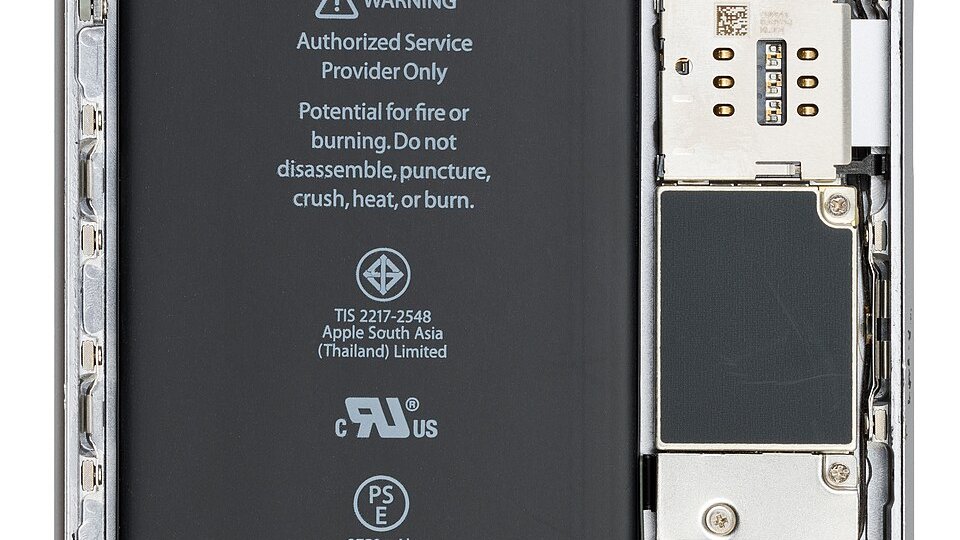 Intérieur d'un iPhone ouvert montrant la batterie lithium-ion et ses avertissements
